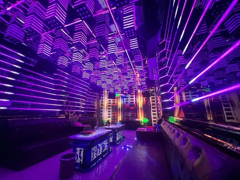 Royal 97 KTV 紫色幾何燈牆與皮革沙發的店內包廂
