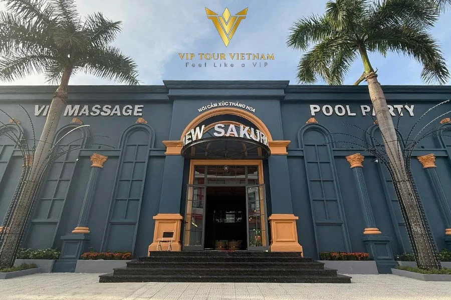 New Sakura Massage 灰藍色建築外觀、金色拱門入口與植栽